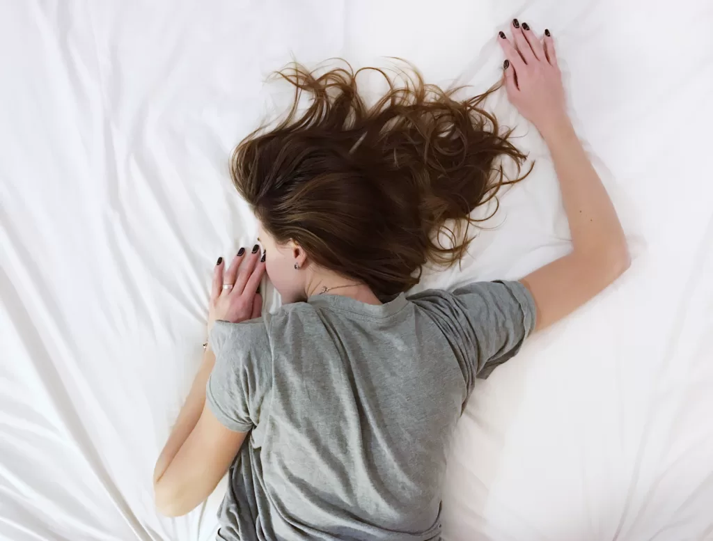 woman laying in bed face-down